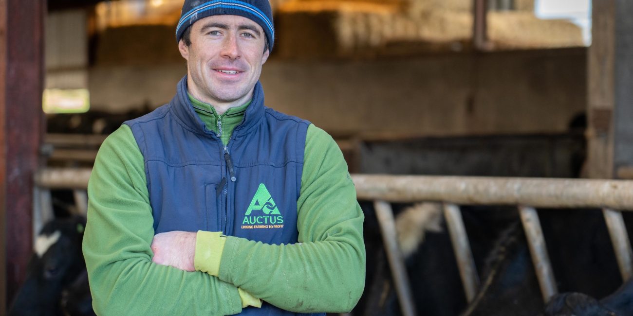 a person in a blue vest and hat with arms crossed